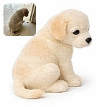 A small puppy sits quietly on a tiled floor, looking down with curiosity at a small dark object near a door frame, bathed in soft natural light.