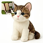 A curious kitten lounges comfortably on a green, tree-shaped scratching post with a textured trunk, its wide eyes gazing directly at the camera in a cozy indoor setting.