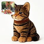 A curious tabby cat sits elegantly on a white round table surrounded by a colorful autumnal display of apples, figs, and a large pumpkin, framed by vibrant red and green foliage in the background and rustic lanterns adding cozy charm.