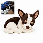 A sleepy little dog is cuddled up on a person's lap, looking like it has bravely completed a long day of being adorable. Wrapped in a bright blue blanket and surrounded by cozy cushions, this pup appears ready for a champion nap.