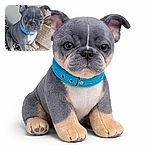 A cute gray and tan puppy with a blue collar is sitting on a cozy beige blanket, giving a charming wink as if sharing a secret joke with the camera.