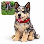 A happy dog with a red harness stands on lush green grass in front of a vibrant flower bed filled with pink and white blossoms, looking like it's enjoying a sunny garden stroll.