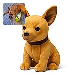 A small tan dog lies on a patterned blanket looking thoughtfully to the side, next to a bright green plush toy shaped like a beer bottle labeled 'Dos Patas Cerveza'. The cozy setting and the dog's calm expression make for a charming, casual snapshot.