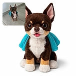 A tiny Chihuahua with a blue towel draped over its back stands on a tiled floor, looking up with big, curious eyes and a slight tongue peek, as if ready to save the day or just ask for a treat.