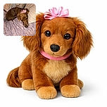 A cute brown dog with a pink ribbon on its head is curled up on a bed with patterned sheets and pillows, giving a sleepy wink to the camera in a cozy indoor setting.