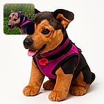 A happy dog wearing a bright pink harness stands in a lush green field with wildflowers and tall grass, looking back with a playful expression and tongue slightly out under a cloudy sky.