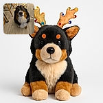 A fluffy dog wearing sparkly reindeer antlers looks up with an adorably confused expression, standing on a wooden floor in a cozy indoor setting surrounded by furniture legs.