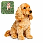 A golden-colored dog with long ears sits attentively on a lush green grassy field, looking off to the side as if pondering the mysteries of the park.