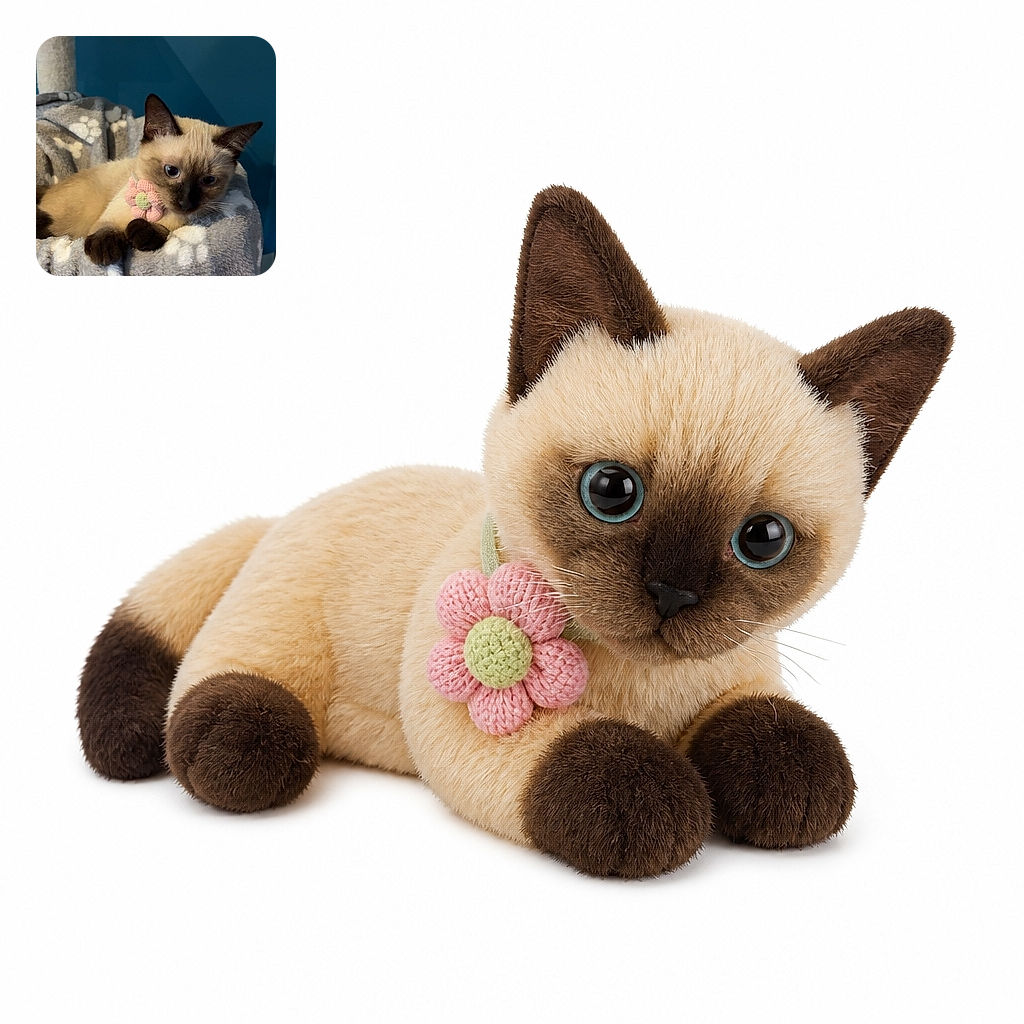 A tiny Siamese kitten lounges like a plush-bedded monarch, wearing a flower collar and giving the camera a wonderfully serious stare while its paws drape over the fuzzy blanket throne.