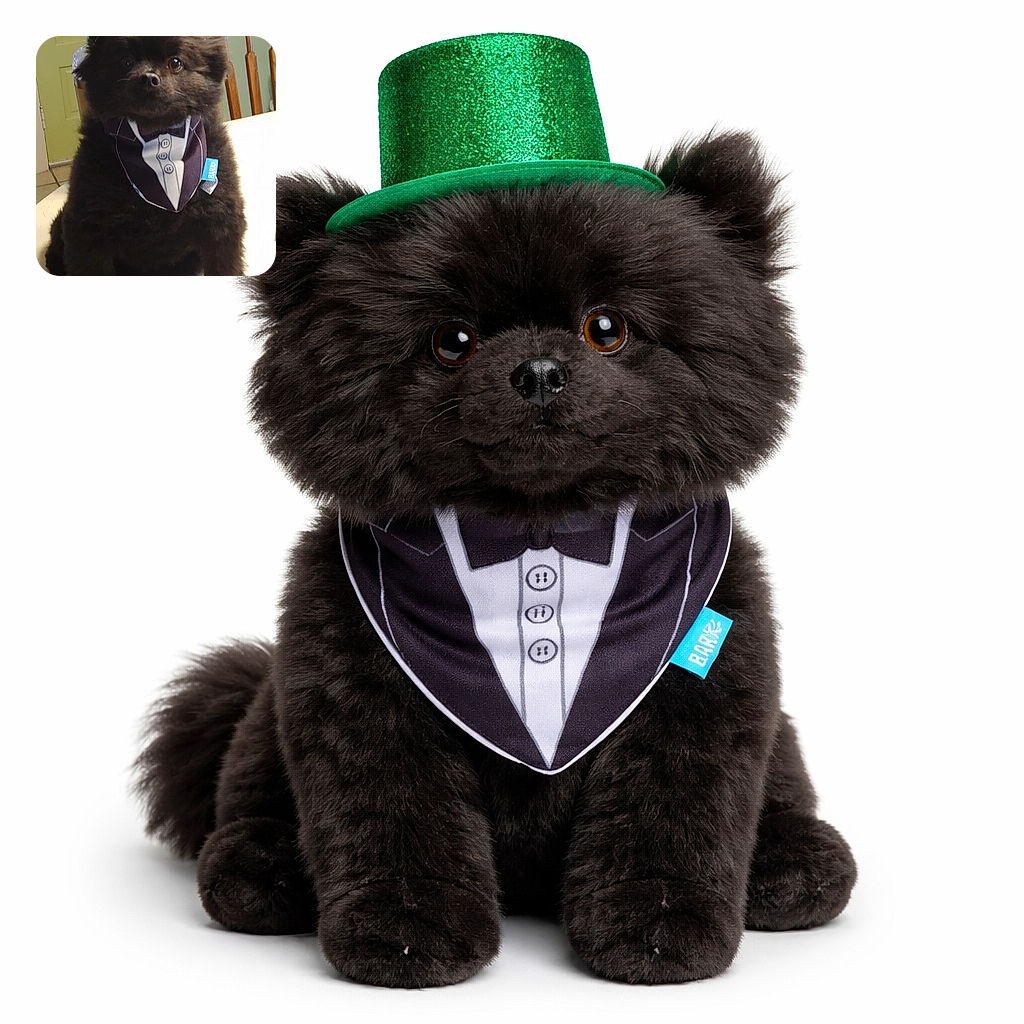 A dignified tiny black dog wearing a sparkly green top hat and a tuxedo-style bandana, sitting proudly on a table like a tiny, well-dressed judge. The fluffy pup stares straight at the camera with big round eyes while a kitchen door and wooden chair form the cozy background — ready for a party or to demand treats.