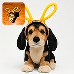 A charming dog wearing colorful bunny ears looks up with wide, curious eyes on a wooden floor, while a human foot peeks into the frame, adding a casual homey vibe.