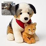 A fluffy dog gently cuddles a sleepy orange tabby kitten on a cozy gray quilted couch, creating a heartwarming scene of unexpected friendship and comfort in a softly lit room.