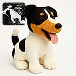 A happy dog with a black and white coat is lying on the grass, tongue out, next to a white ball, captured in a sharp and artistic black and white photo.