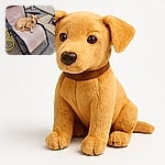 A relaxed tan dog is comfortably lounging on a beige outdoor recliner chair, looking calmly at the camera. The setting is a tiled patio with a yellow garden hose coiled nearby and a broom leaning against the wall in the background.