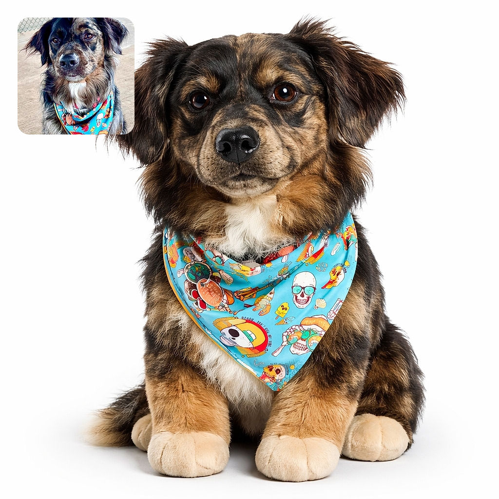 A charming dog with soulful eyes sports a colorful, quirky bandana adorned with skulls, ice cream, and beach motifs, sitting attentively in front of a chain-link fence on a concrete ground.