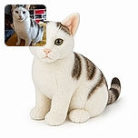 A very serious white-and-gray cat stands proudly on a mustard-yellow bedspread, staring into the camera like it has just been elected CEO of the living room. Behind it, a television, shelves, and assorted household treasures complete the cozy indoor scene, while the phone watermark quietly documents the official portrait session.