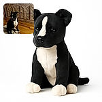 A charming black and white dog sits patiently on a textured rug in front of an ornately carved wooden cabinet. The warm wooden floor complements the rustic background, creating a cozy indoor scene where the dog's curious expression steals the show.