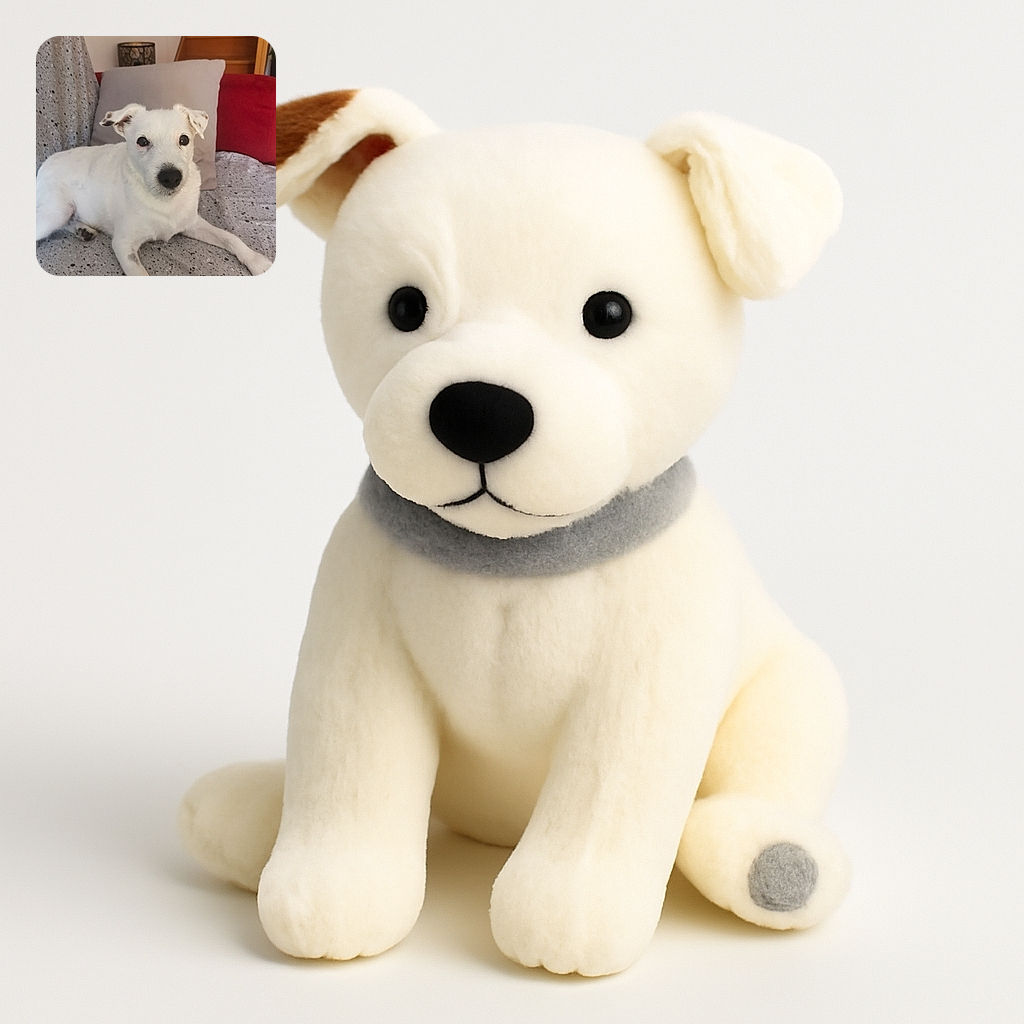 A charming white dog lounges comfortably on a speckled blanket with a cozy pillow and a red couch in the background, looking curiously at the camera with a gentle expression.