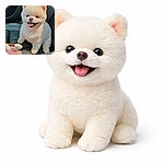 A fluffy white Pomeranian grins with its tongue out, perched on a car seat next to a plush toy — a tiny cloud of joy ready for selfie duty.