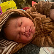 Jason is registered to the contest to win money with this photo: baby, sleeping, hooded_jacket, brown_clothing, infant, closeup, face, hand, soft_texture, striped_fabric, cozy, warm_clothing, indoor, resting, cute, newborn, child, portrait, peaceful, relaxed