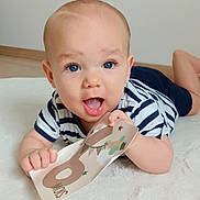 Sohan participe au concours pour gagner de l'argent avec cette photo : baby, infant, blue_eyes, smiling, striped_shirt, milestone_card, 6_months, fluffy_rug, lying_down, cute, child, portrait, indoor, happy, hand, face, mouth_open, skin, short_hair, floor