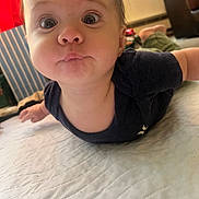 Jackson joined the competition — help win amazing prizes! baby, infant, face, wide_eyes, expression, lying_down, quilt, blanket, indoor, child, curious, cute, person, skin, clothing, head, floor, home, toddler, young