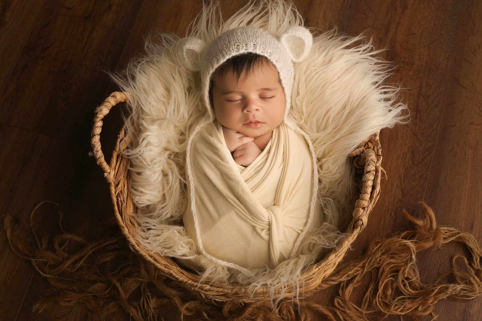 Izza participe au concours pour gagner de l'argent avec cette photo : baby, infant, swaddled, basket, knit_hat, bear_ears, sleeping, cozy, fluffy, blanket, wooden_floor, cute, newborn, peaceful, portrait, soft_textures, indoors, resting, child, adorable