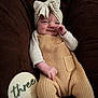 baby, child, couch, cozy, cute, happy, headband, indoor, infant, knitwear, milestone, months, outfit, person, plush, portrait, sign, smile, warm, wood
