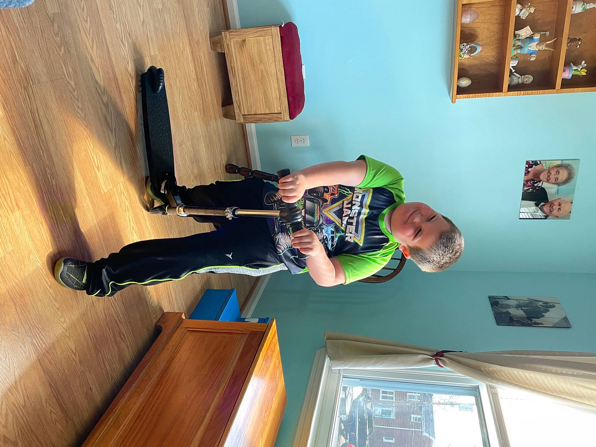 Matthew Jr is registered to the contest to win money with this photo: child, comfort, elbow, flooring, fun, hardwood, human_leg, joy, knee, leisure, person, picture_frame, room, shelf, t_shirt, thigh, toddler, visual_arts, window, wood