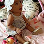 Valentina is registered to the contest to win money with this photo: baby, child, childrens_toy, cozy, curious, cushion, cute, doll, dress, floral_pattern, footwear, hat, indoor, infant, patterned_clothing, pink, play_mat, sitting, soft_toy, toy