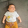 baby, infant, child, couch, striped_couch, white_shirt, cartoon_animals, mustard_pants, fox_design, socks, yellow_socks, person, legs, lace_clothing, resting, indoor, portrait, cute, lying_down, looking_away