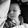 baby, sleeping, blanket, pillow, cozy, infant, black_and_white, face, peaceful, soft_texture, closeup, portrait, child, indoors, resting, clothing, cute, toddler, nap, serene