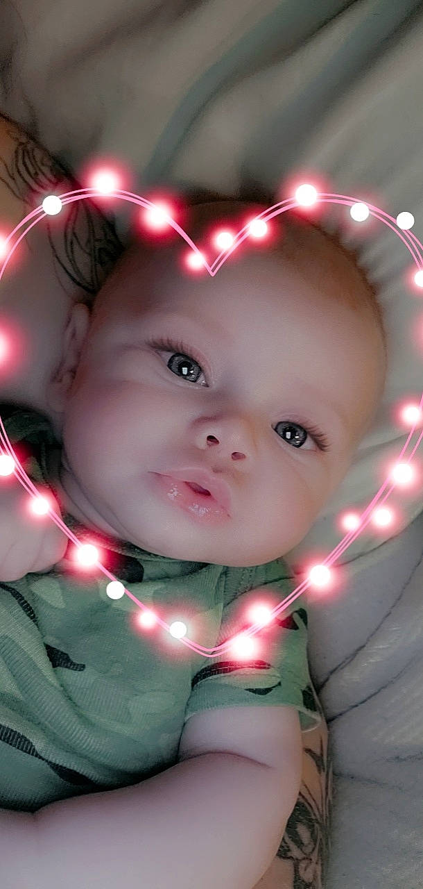 Aayla is registered to the contest to win money with this photo: baby, baby_toddler_clothing, cheek, christmas_ornament, eye, eyebrow, eyelash, flash_photography, fun, happy, head, iris, light, lip, mouth, nose, person, pink, skin, toddler