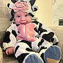 baby, child, costume, cow_costume, couch, smile, blue_eyes, plush, indoors, cute, infant, apparel, footwear, sitting, happy, portrait, soft, cozy, furniture, baby_clothes