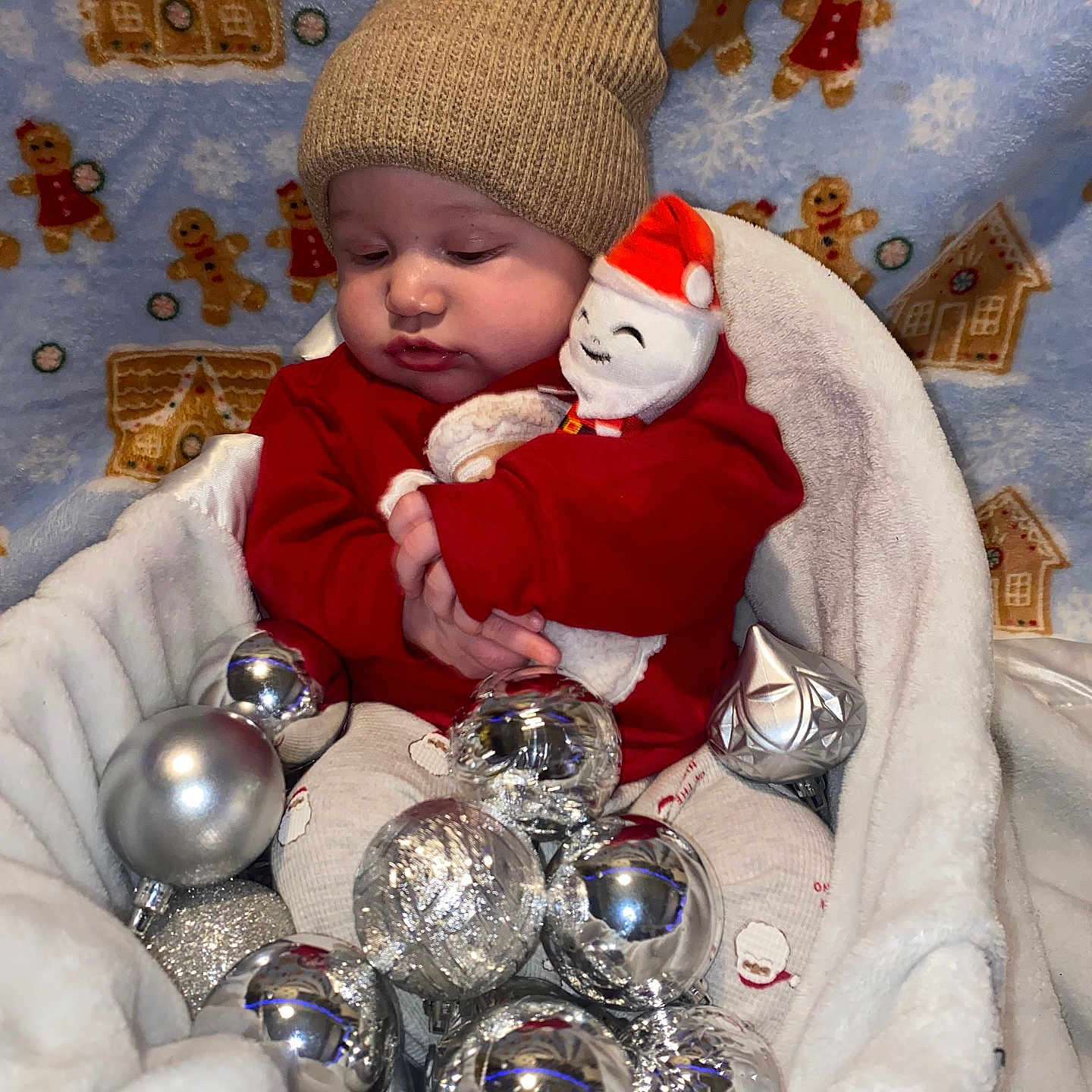 Javonte is registered to the contest to win money with this photo: baby, blanket, child, christmas_ornaments, cozy, cute, festive, gingerbread, hat, holiday, indoor, infant, knitted_hat, pattern, plush_toy, portrait, santa_toy, silver_balls, smiling_toy, soft_fabric