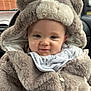 baby, child, hood, jacket, fur, bib, animal_print, car_interior, seat, cute, smile, face, portrait, warm_clothing, childhood, infant, cozy, soft_texture, closeup, adorable