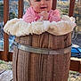 Wednesday joined the competition — help win amazing prizes! baby, baby_girl, background, barrel, child, cute, daylight, expression, face, fuzzy_blanket, happy, infant, nature, outdoor, pink_bow, pink_clothing, porch, smiling, wood, wooden_barrel