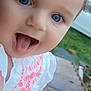 baby, child, face, blue_eyes, tongue_out, white_shirt, embroidered_clothing, outdoor, patio, greenery, car, closeup, cute, playful, person, infant, smiling, young_child, headshot, daylight