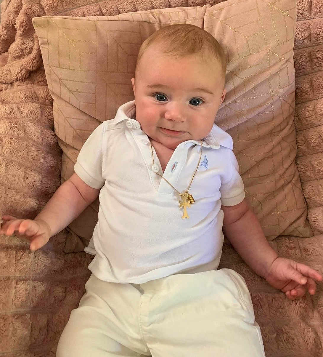 Tigran a rejoint le concours — aidez-le/la à gagner de superbes lots ! baby, child, infant, white_clothing, polo_shirt, gold_necklace, plush_blanket, decorative_pillow, couch, smiling, cute, portrait, indoors, relaxed, happy, person, young_child, sitting, skin, face