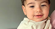 Isaac is registered to the contest to win money with this photo: toddler, child, smile, face, hair, skin, indoors, person, baby, cute, portrait, clothing, short_sleeves, furniture, living_room, couch, soft_light, happy, holding, human