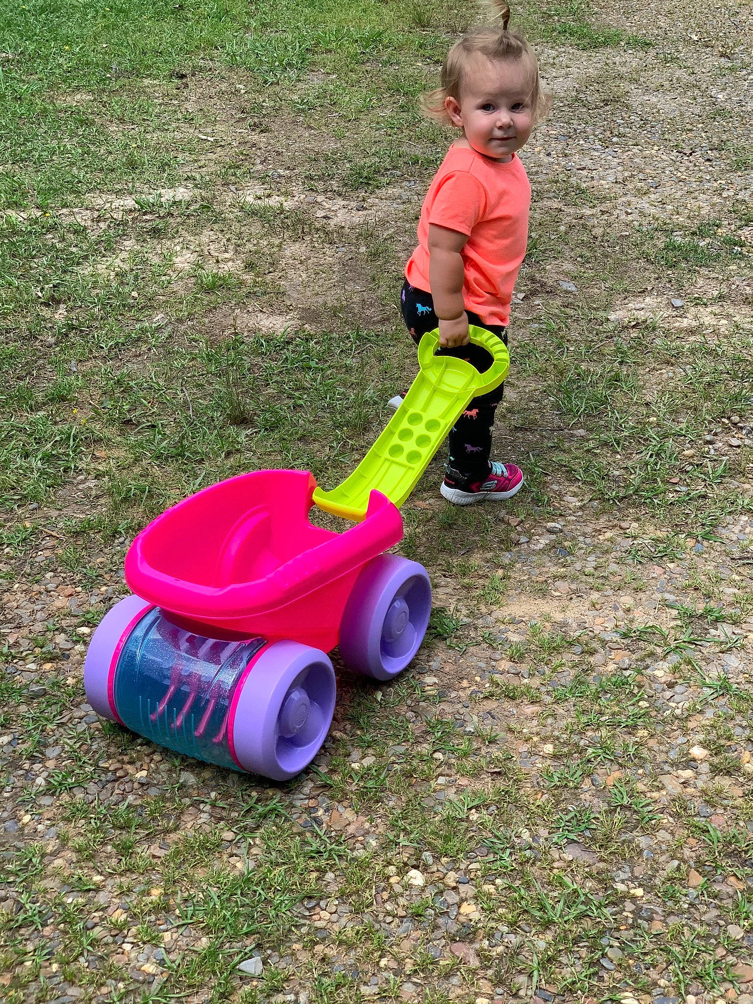Madeline is registered to the contest to win money with this photo: child, fun, grass, lawn, person, play, riding_toy, toddler, vehicle
