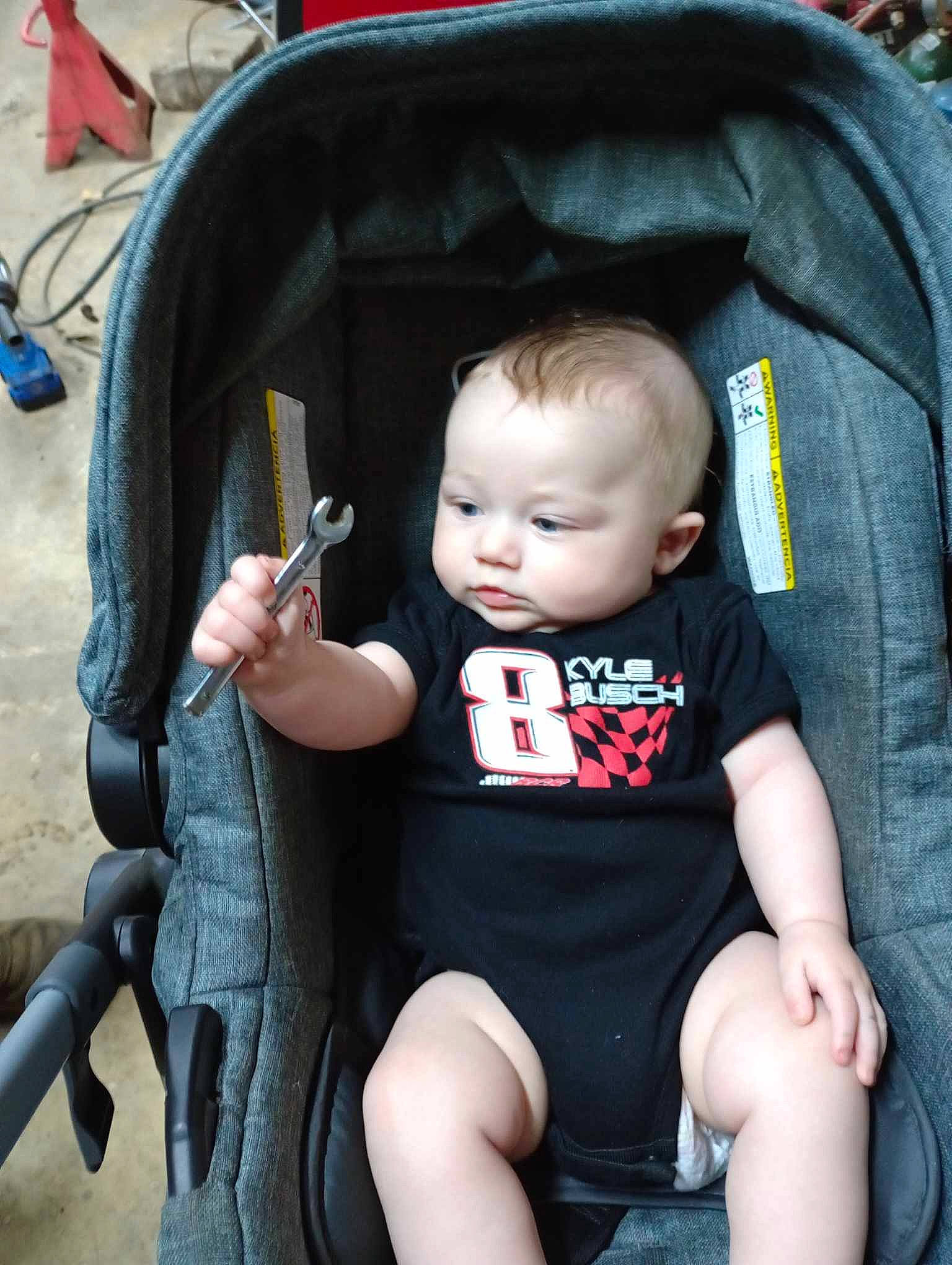 Nathaniel is registered to the contest to win money with this photo: baby, baby_carriage, baby_products, baby_toddler_clothing, blue, chair, cheek, child, comfort, cool, eye, facial_expression, fun, head, lap, leg, person, photograph, product, skin