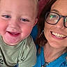child, toddler, woman, smile, glasses, necklace, heart_shaped_jewelry, casual_clothing, indoor, portrait, happy, closeup, face, human, cheerful, skin, blue_shirt, green_shirt, person, family
