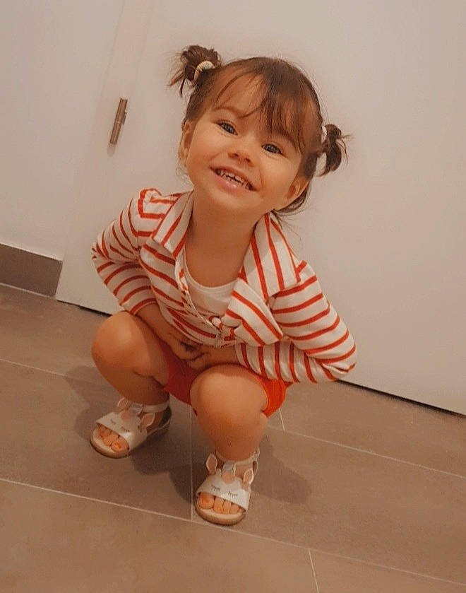 Victoria participe au concours pour gagner de l'argent avec cette photo : baby_toddler_clothing, cheek, face, flooring, foot, gesture, happy, human_body, human_leg, joy, knee, leg, person, sandal, shoe, sleeve, smile, sneakers, sock, thigh