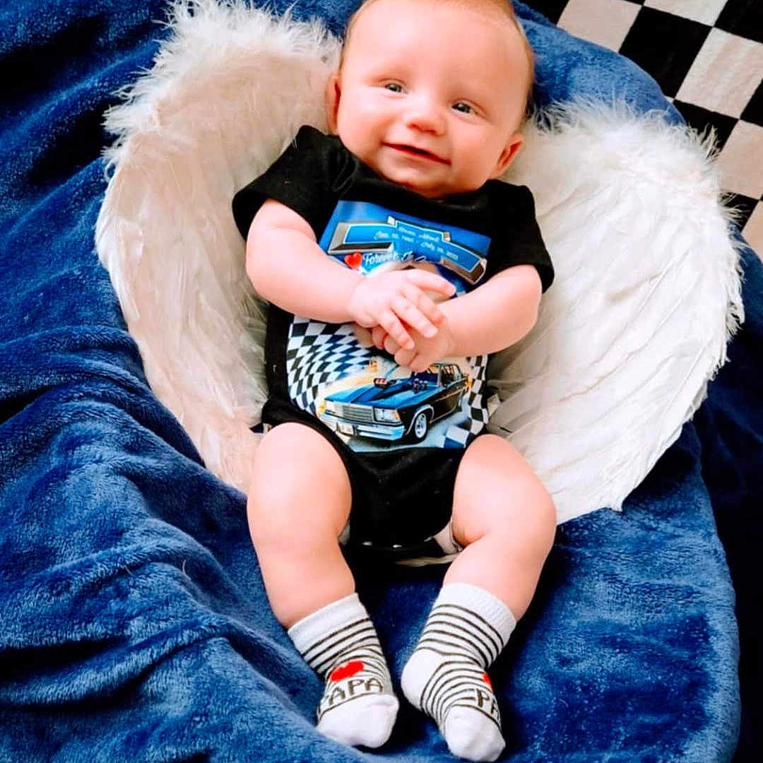 Kadyn is registered to the contest to win money with this photo: baby, blanket, clothing, couch, cushion, face, furniture, head, homedecor, hosiery, newborn, pants, person, photography, portrait, shorts, sitting, sleeping, sock, t_shirt