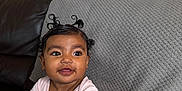 Sierra joined the competition — help win amazing prizes! baby, blanket, child, couch, cozy, curly_hair, curly_hairstyle, cute, face, happy, home, indoor, infant, person, pink_shirt, portrait, sitting, smile, white_pants, young_child