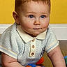 baby, child, crawling, blue_eyes, knit_shirt, buttons, toy, colorful, floor, yellow_wall, curious, innocent, indoor, portrait, cute, chubby_cheeks, person, young_child, playful, closeup