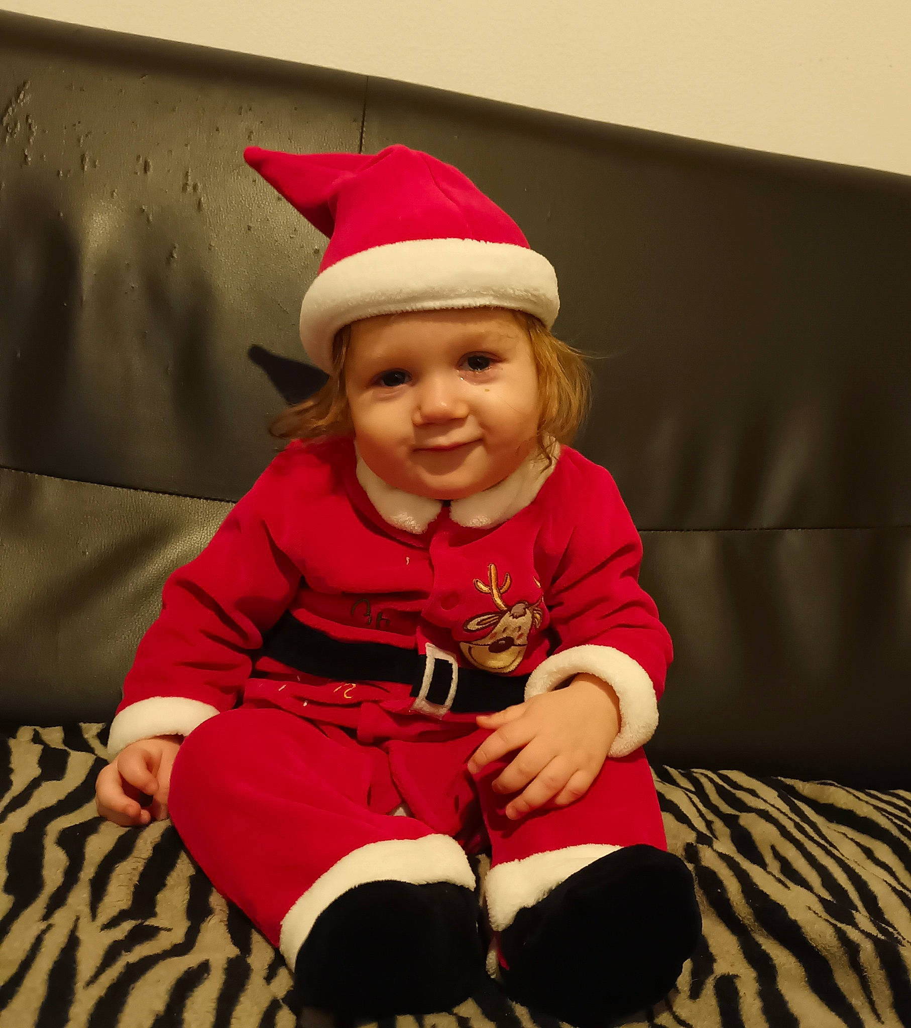 Kélyo participe au concours pour gagner de l'argent avec cette photo : baby_toddler_clothing, cap, child, christmas, comfort, costume_hat, event, eye, face, fun, happy, hat, head, headwear, joy, lap, person, red, sitting, sleeve