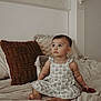 toddler, child, baby, dress, bed, pillow, indoors, curly_hair, sitting, looking_up, cute, soft_light, home, cozy, infant, person, furniture, skin, barefoot, toy