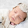 baby, sleeping, headband, flower, pearl, knit_blanket, teddy_bear, soft_toy, cozy, infant, cute, peaceful, closeup, portrait, newborn, child, face, hand, resting, white_background